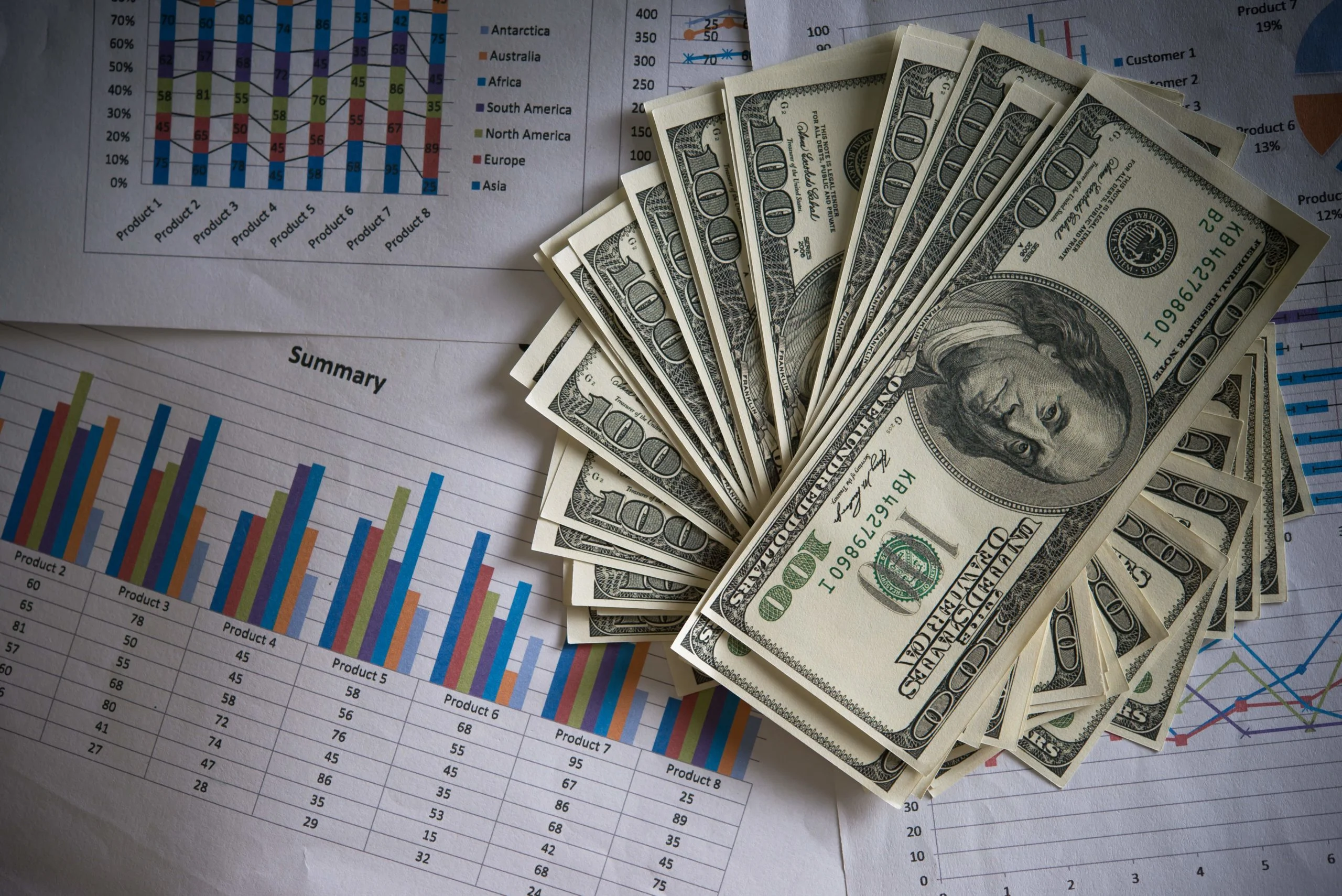 Brokers trading: billetes sobre una hojas de papel con gráficas.